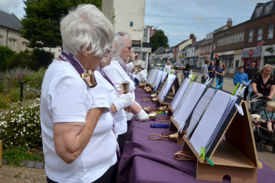 Dunkeswell Handbell Ringers performing outside St Paul's Church on Honiton Market Charter Day 2025
