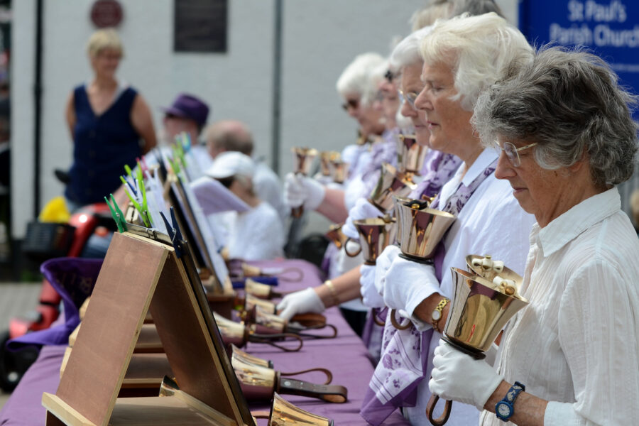 Dunkeswell Handbell Ringers performing outside St Paul's Church on Honiton Market Charter Day 2025