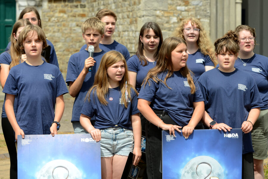 Members of Honiton Community Theatre Company performing outside St Paul's Church on Honiton Market Charter Day 2025