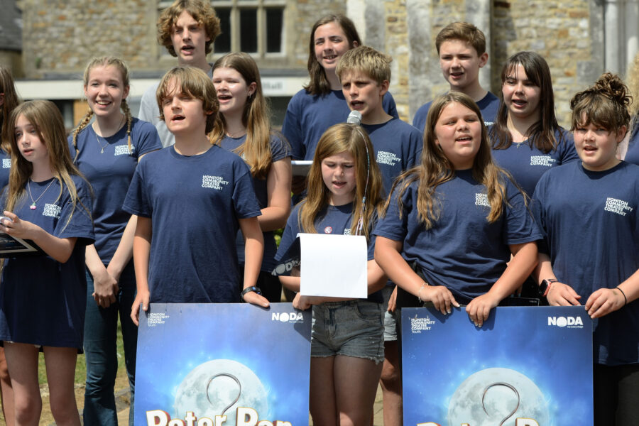 Members of Honiton Community Theatre Company performing outside St Paul's Church on Honiton Market Charter Day 2025